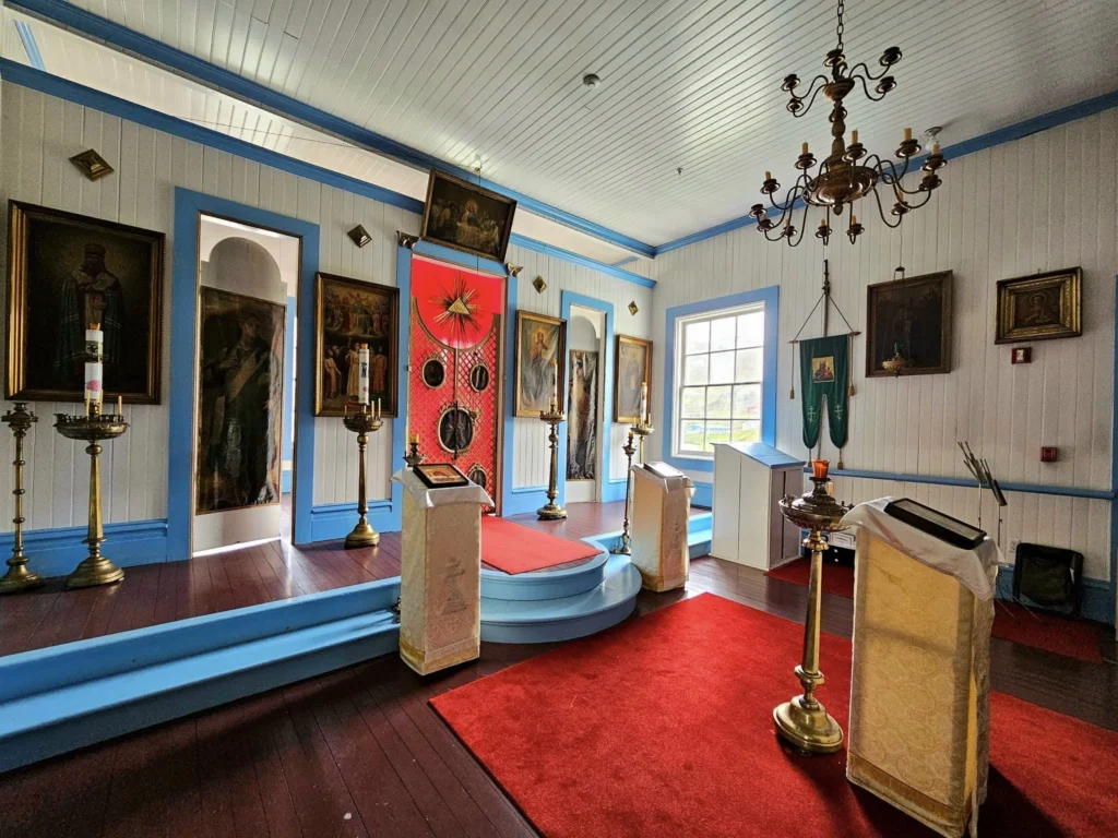 Cruising with Danny and Peter, Holland America Line, Westerdam, Dutch Harbor, Unlaska, Alaska, United States | Scenic view of Dutch Harbor Unalaska featuring rugged mountains and the Bering Sea, with a hiker on Mount Ballyhoo Trail, a majestic bald eagle soaring above, and the historic Russian Orthodox Church with its distinctive onion domes. Includes a fresh seafood dish representing local cuisine and a birdwatching spot at Unalaska Island Bird Sanctuary, capturing the charm of Unalaska's blend of natural beauty, wildlife, and cultural heritage.