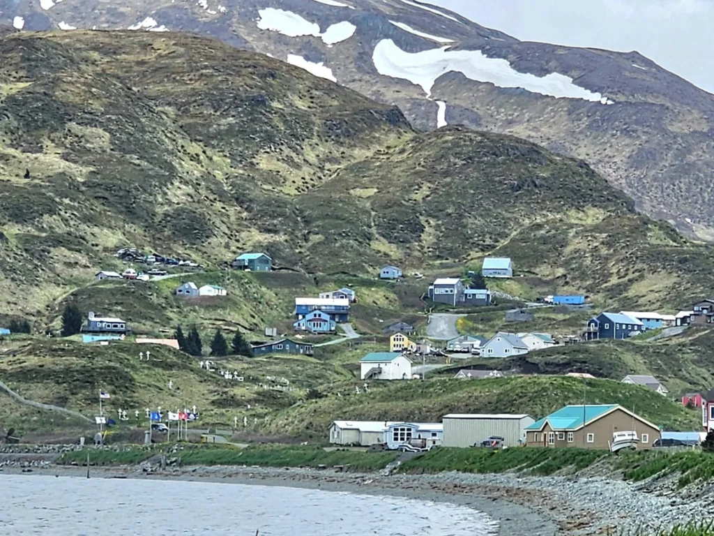 Cruising with Danny and Peter, Holland America Line, Westerdam, Dutch Harbor, Unlaska, Alaska, United States | Scenic view of Dutch Harbor Unalaska featuring rugged mountains and the Bering Sea, with a hiker on Mount Ballyhoo Trail, a majestic bald eagle soaring above, and the historic Russian Orthodox Church with its distinctive onion domes. Includes a fresh seafood dish representing local cuisine and a birdwatching spot at Unalaska Island Bird Sanctuary, capturing the charm of Unalaska's blend of natural beauty, wildlife, and cultural heritage.