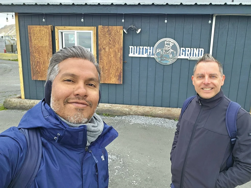 Cruising with Danny and Peter, Holland America Line, Westerdam, Dutch Harbor, Unlaska, Alaska, United States | Scenic view of Dutch Harbor Unalaska featuring rugged mountains and the Bering Sea, with a hiker on Mount Ballyhoo Trail, a majestic bald eagle soaring above, and the historic Russian Orthodox Church with its distinctive onion domes. Includes a fresh seafood dish representing local cuisine and a birdwatching spot at Unalaska Island Bird Sanctuary, capturing the charm of Unalaska's blend of natural beauty, wildlife, and cultural heritage.