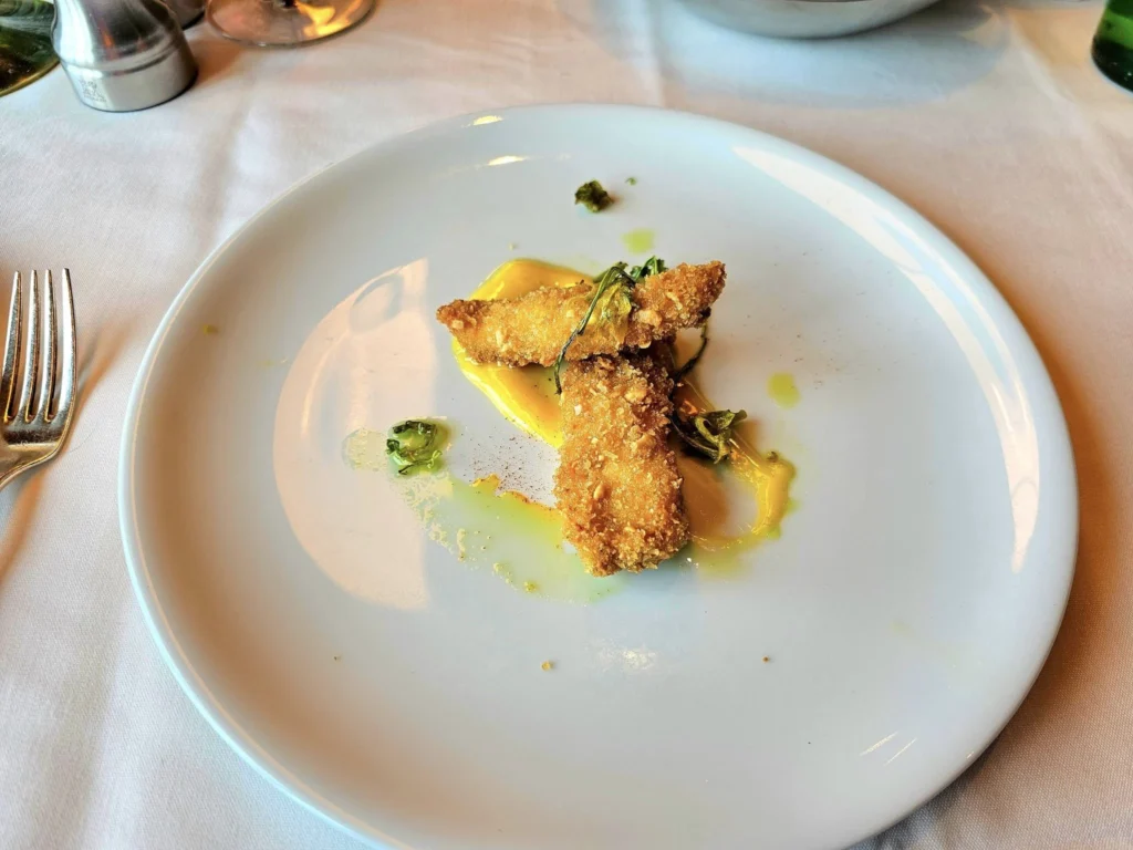 Cruising with Danny and Peter, Holland America Line, Westerdam, Bering Sea, Alaska, United States, Arctic Circle Adventure | A vibrant scene aboard Holland America Line’s Westerdam during the Alaska Arctic Circle Solstice cruise in the Bering Sea, Alaska, United States. Passengers gather around the Lido pool, preparing for the exhilarating Polar Bear Plunge, with crew members setting up the chilled pool to simulate Arctic waters. In the background, stunning Arctic landscapes unfold, featuring pristine ice floes floating on deep blue waters under a golden-hued sky, with distant glaciers and occasional wildlife, such as seals and seabirds, enhancing the untamed beauty of the Frozen Sea Adventure.