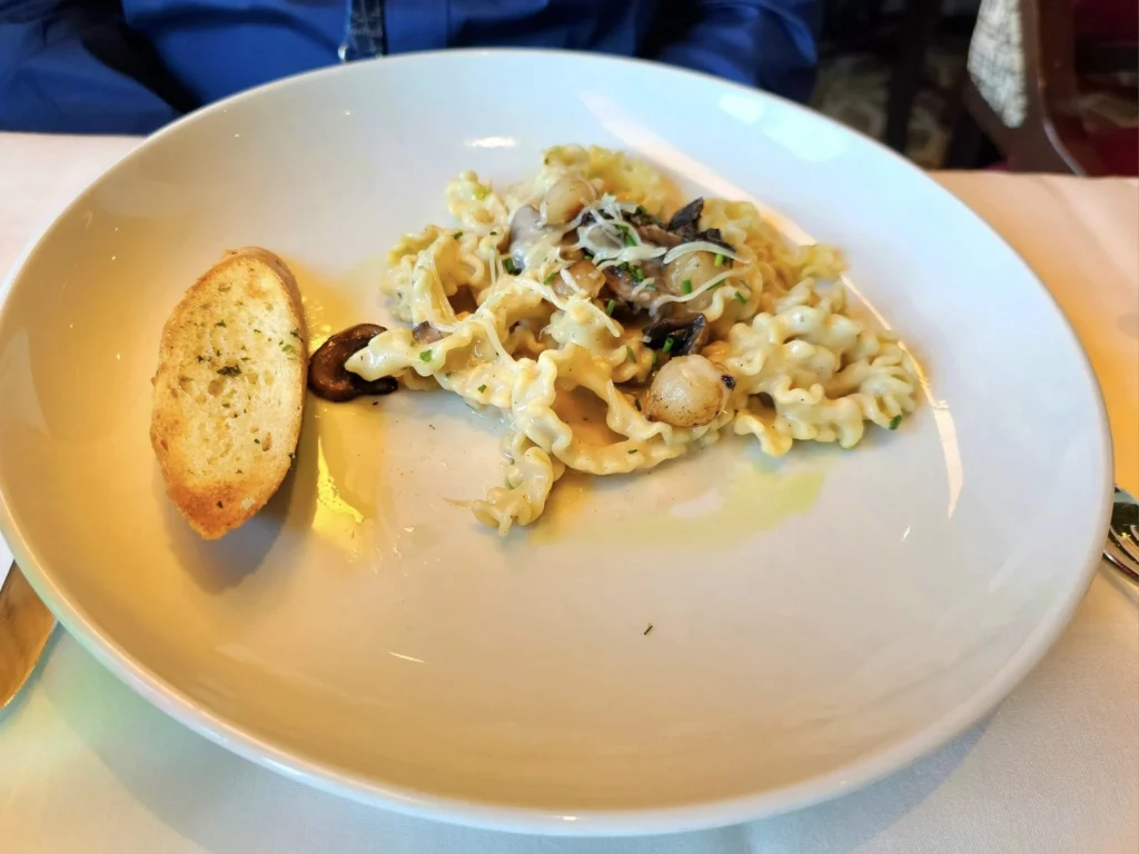 Cruising with Danny and Peter, Holland America Line, Westerdam, Bering Sea, Alaska, United States, Arctic Circle Adventure | A vibrant scene aboard Holland America Line’s Westerdam during the Alaska Arctic Circle Solstice cruise in the Bering Sea, Alaska, United States. Passengers gather around the Lido pool, preparing for the exhilarating Polar Bear Plunge, with crew members setting up the chilled pool to simulate Arctic waters. In the background, stunning Arctic landscapes unfold, featuring pristine ice floes floating on deep blue waters under a golden-hued sky, with distant glaciers and occasional wildlife, such as seals and seabirds, enhancing the untamed beauty of the Frozen Sea Adventure.