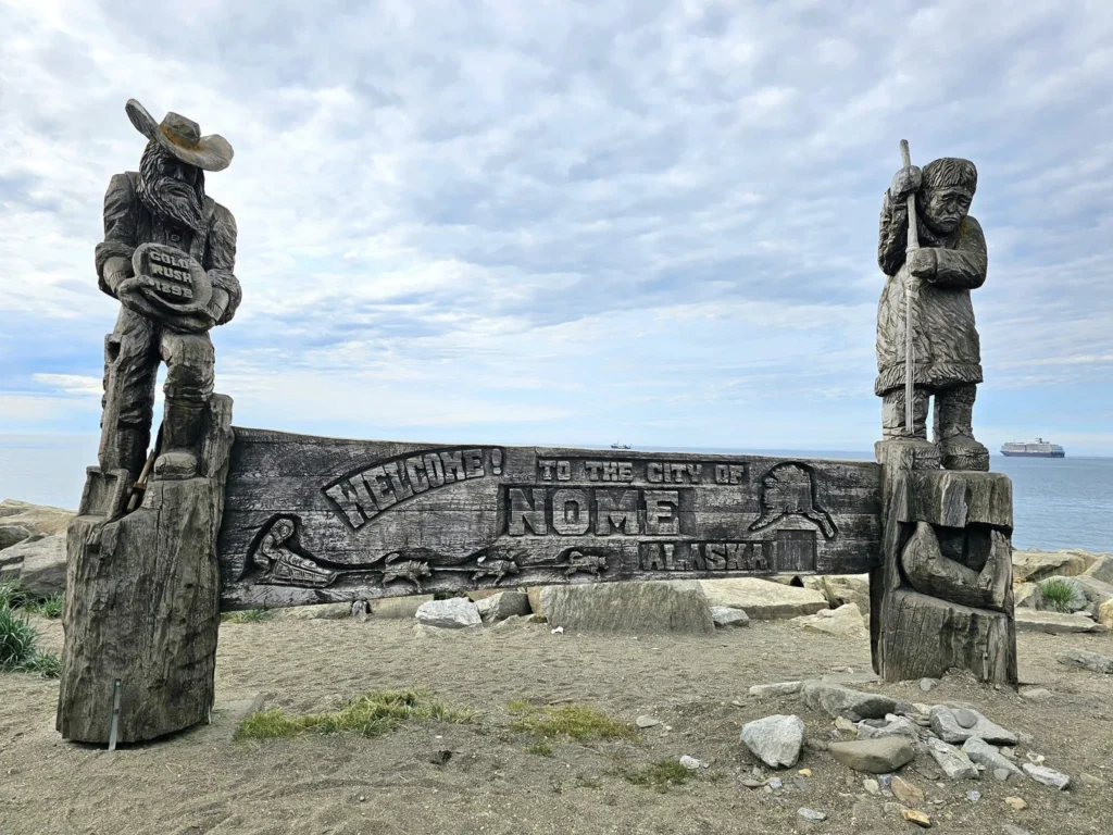 Discovering Newton Peak Hike in Nome, Alaska: A Comprehensive Adventure Guide 34 Cruising with Danny and Peter, Holland America Line, Westerdam, Nome, Alaska, United States | Scenic images of the Newton Peak Hike in Nome, Alaska, including the trailhead marking the start of the adventure, hikers ascending the challenging terrain, panoramic summit views of rolling hills and the Bering Sea, wildlife like curious squirrels and soaring birds along the trail, and vibrant wildflowers adding color to the rugged landscape.