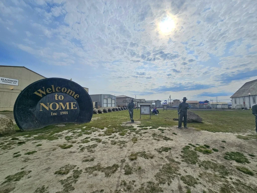 Discovering Newton Peak Hike in Nome, Alaska: A Comprehensive Adventure Guide 2 Cruising with Danny and Peter, Holland America Line, Westerdam, Nome, Alaska, United States | Scenic images of the Newton Peak Hike in Nome, Alaska, including the trailhead marking the start of the adventure, hikers ascending the challenging terrain, panoramic summit views of rolling hills and the Bering Sea, wildlife like curious squirrels and soaring birds along the trail, and vibrant wildflowers adding color to the rugged landscape.
