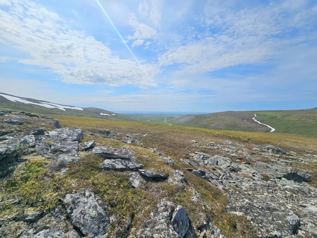 Discovering Newton Peak Hike in Nome, Alaska: A Comprehensive Adventure Guide 54 Cruising with Danny and Peter, Holland America Line, Westerdam, Nome, Alaska, United States | Scenic images of the Newton Peak Hike in Nome, Alaska, including the trailhead marking the start of the adventure, hikers ascending the challenging terrain, panoramic summit views of rolling hills and the Bering Sea, wildlife like curious squirrels and soaring birds along the trail, and vibrant wildflowers adding color to the rugged landscape.