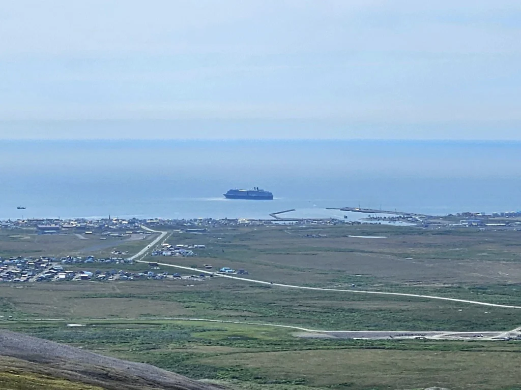Discovering Newton Peak Hike in Nome, Alaska: A Comprehensive Adventure Guide 68 Cruising with Danny and Peter, Holland America Line, Westerdam, Nome, Alaska, United States | Scenic images of the Newton Peak Hike in Nome, Alaska, including the trailhead marking the start of the adventure, hikers ascending the challenging terrain, panoramic summit views of rolling hills and the Bering Sea, wildlife like curious squirrels and soaring birds along the trail, and vibrant wildflowers adding color to the rugged landscape.