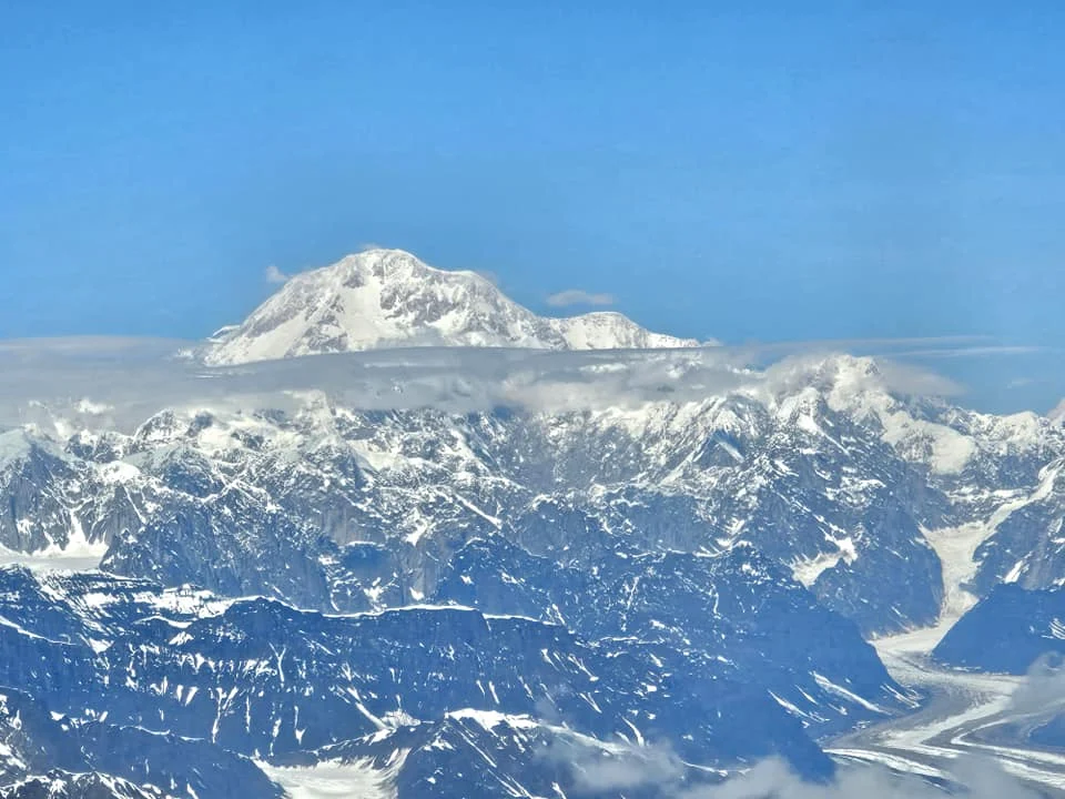 Unforgettable Alaska Flightseeing: A Journey Over Denali National Park 35 Cruising with Danny and Peter, Holland America Line, Westerdam, Anchorage, Alaska, United States | Aerial view of Denali, North America's tallest peak, and the majestic Alaska Range, captured during a Denali National Park flightseeing tour from Anchorage. The image also shows the stunning Ruth Glacier, a specialized plane with skis landing on Denali's snowy terrain, and wildlife such as moose grazing and beluga whales swimming in Cook Inlet.