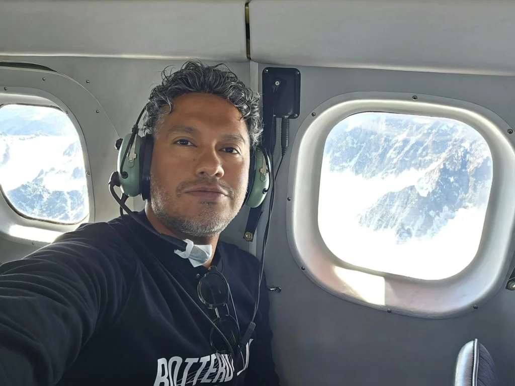 Unforgettable Alaska Flightseeing: A Journey Over Denali National Park 37 Cruising with Danny and Peter, Holland America Line, Westerdam, Anchorage, Alaska, United States | Aerial view of Denali, North America's tallest peak, and the majestic Alaska Range, captured during a Denali National Park flightseeing tour from Anchorage. The image also shows the stunning Ruth Glacier, a specialized plane with skis landing on Denali's snowy terrain, and wildlife such as moose grazing and beluga whales swimming in Cook Inlet.