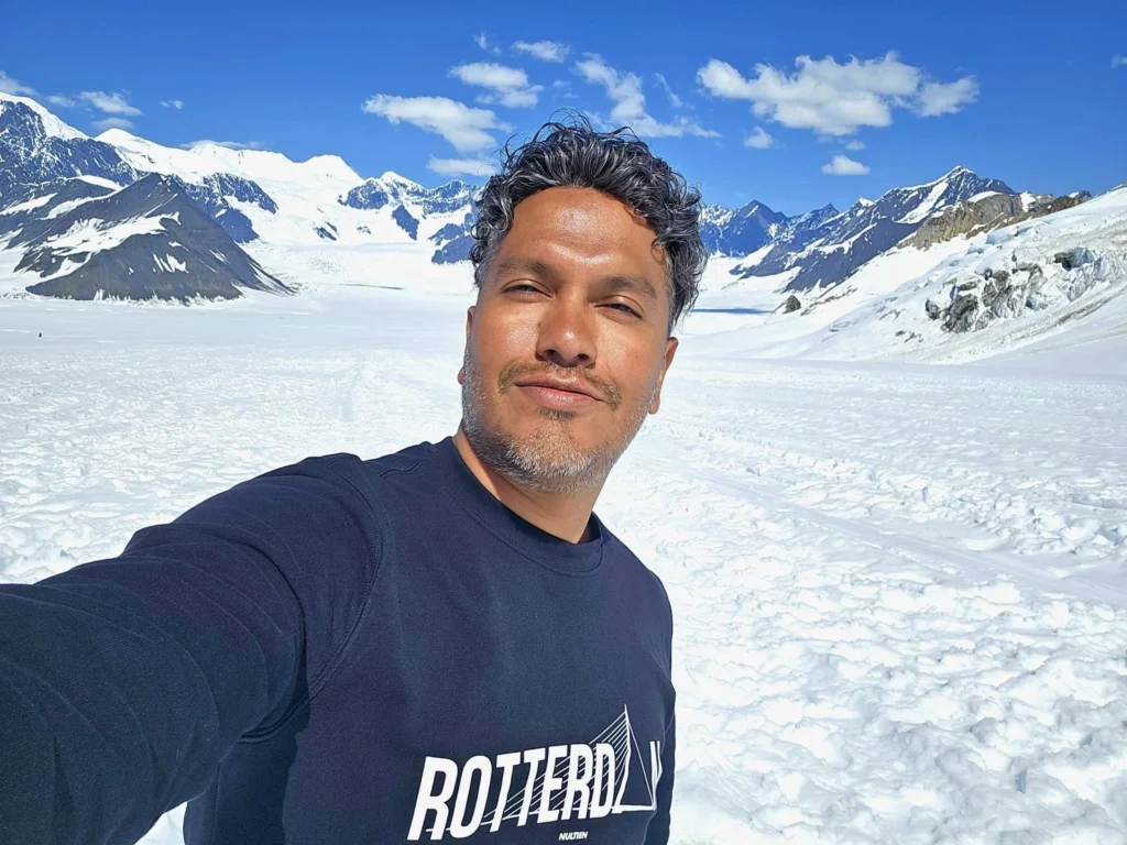 Unforgettable Alaska Flightseeing: A Journey Over Denali National Park 53 Cruising with Danny and Peter, Holland America Line, Westerdam, Anchorage, Alaska, United States | Aerial view of Denali, North America's tallest peak, and the majestic Alaska Range, captured during a Denali National Park flightseeing tour from Anchorage. The image also shows the stunning Ruth Glacier, a specialized plane with skis landing on Denali's snowy terrain, and wildlife such as moose grazing and beluga whales swimming in Cook Inlet.