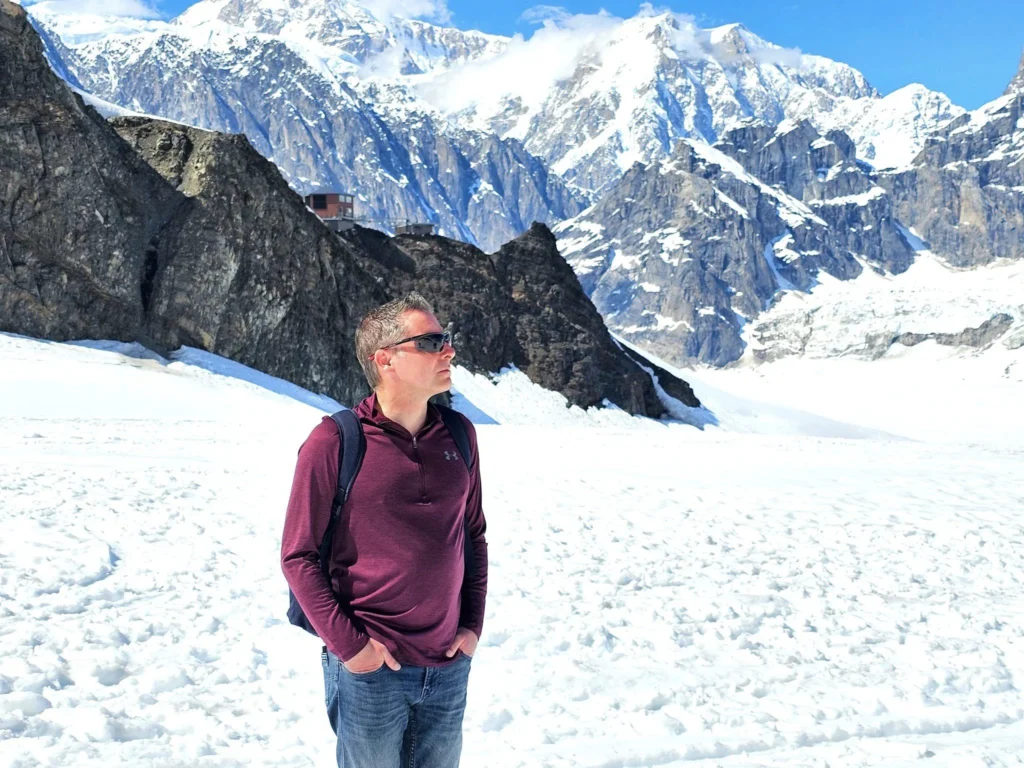 Unforgettable Alaska Flightseeing: A Journey Over Denali National Park 67 Cruising with Danny and Peter, Holland America Line, Westerdam, Anchorage, Alaska, United States | Aerial view of Denali, North America's tallest peak, and the majestic Alaska Range, captured during a Denali National Park flightseeing tour from Anchorage. The image also shows the stunning Ruth Glacier, a specialized plane with skis landing on Denali's snowy terrain, and wildlife such as moose grazing and beluga whales swimming in Cook Inlet.