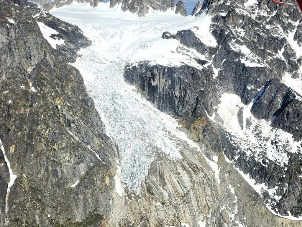 Unforgettable Alaska Flightseeing: A Journey Over Denali National Park 71 Cruising with Danny and Peter, Holland America Line, Westerdam, Anchorage, Alaska, United States | Aerial view of Denali, North America's tallest peak, and the majestic Alaska Range, captured during a Denali National Park flightseeing tour from Anchorage. The image also shows the stunning Ruth Glacier, a specialized plane with skis landing on Denali's snowy terrain, and wildlife such as moose grazing and beluga whales swimming in Cook Inlet.
