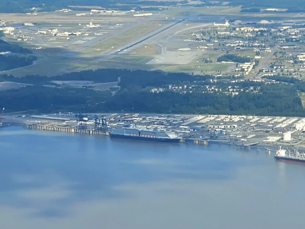 Unforgettable Alaska Flightseeing: A Journey Over Denali National Park 78 Cruising with Danny and Peter, Holland America Line, Westerdam, Anchorage, Alaska, United States | Aerial view of Denali, North America's tallest peak, and the majestic Alaska Range, captured during a Denali National Park flightseeing tour from Anchorage. The image also shows the stunning Ruth Glacier, a specialized plane with skis landing on Denali's snowy terrain, and wildlife such as moose grazing and beluga whales swimming in Cook Inlet.