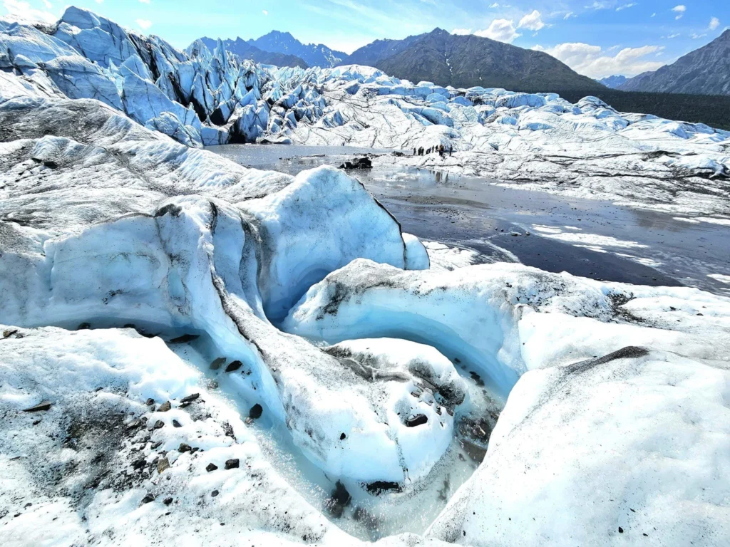 Cruising with Danny and Peter, Holland America Line, Westerdam, Anchorage, Alaska, United States | Experience the Matanuska Glacier Tour with stunning views of the glacier’s vast ice formations, an all-terrain vehicle ride, thrilling glacier hikes, and the unique refreshment of drinking crystal-clear glacial water, all complemented by stops at charming local eateries offering authentic Alaskan cuisine.