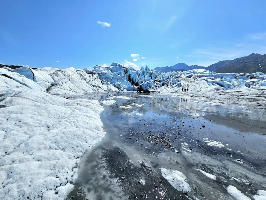 Cruising with Danny and Peter, Holland America Line, Westerdam, Anchorage, Alaska, United States | Experience the Matanuska Glacier Tour with stunning views of the glacier’s vast ice formations, an all-terrain vehicle ride, thrilling glacier hikes, and the unique refreshment of drinking crystal-clear glacial water, all complemented by stops at charming local eateries offering authentic Alaskan cuisine.