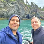 Cruising with Danny and Peter, Holland America Line, Westerdam, Spit (Homer), Alaska, United States | Boat on a morning water tour near Spit with Alaska Water Taxi & Charter, showing seabirds in flight, playful seals in Peterson Bay, sea otters in Cook Inlet, and guests enjoying The Orange Party on the Westerdam. Highlights include scenic boardwalk in Spit and a delicious Alaska seafood boil at Lido Market.