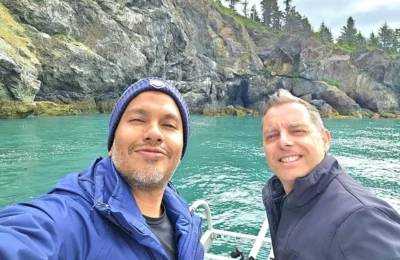 Cruising with Danny and Peter, Holland America Line, Westerdam, Spit (Homer), Alaska, United States | Boat on a morning water tour near Spit with Alaska Water Taxi & Charter, showing seabirds in flight, playful seals in Peterson Bay, sea otters in Cook Inlet, and guests enjoying The Orange Party on the Westerdam. Highlights include scenic boardwalk in Spit and a delicious Alaska seafood boil at Lido Market.