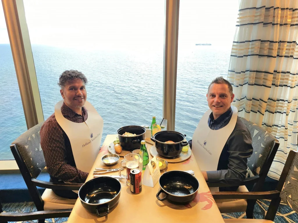 Cruising with Danny and Peter, Holland America Line, Westerdam, Spit (Homer), Alaska, United States | Boat on a morning water tour near Spit with Alaska Water Taxi & Charter, showing seabirds in flight, playful seals in Peterson Bay, sea otters in Cook Inlet, and guests enjoying The Orange Party on the Westerdam. Highlights include scenic boardwalk in Spit and a delicious Alaska seafood boil at Lido Market.