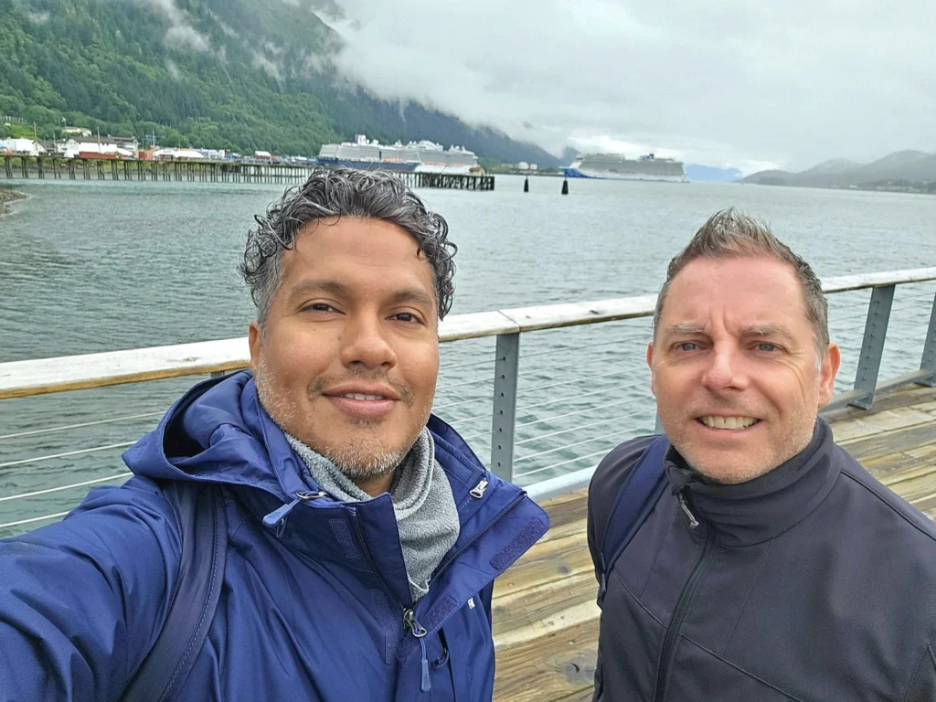 Cruising with Danny and Peter, Holland America Line, Westerdam, Juneau, Alaska, United States | Boat approaching Sentinel Island Lighthouse during Alaska whale watching tour, with humpback whale and stunning coastal scenery in the background.