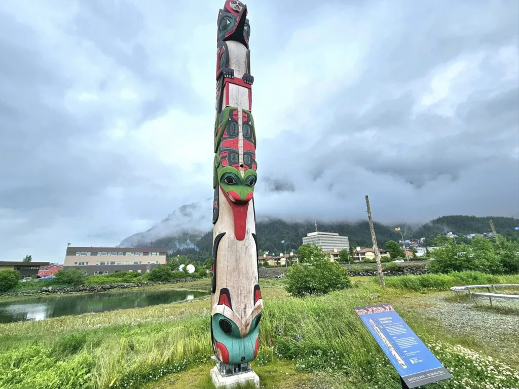 Cruising with Danny and Peter, Holland America Line, Westerdam, Juneau, Alaska, United States | Boat approaching Sentinel Island Lighthouse during Alaska whale watching tour, with humpback whale and stunning coastal scenery in the background.