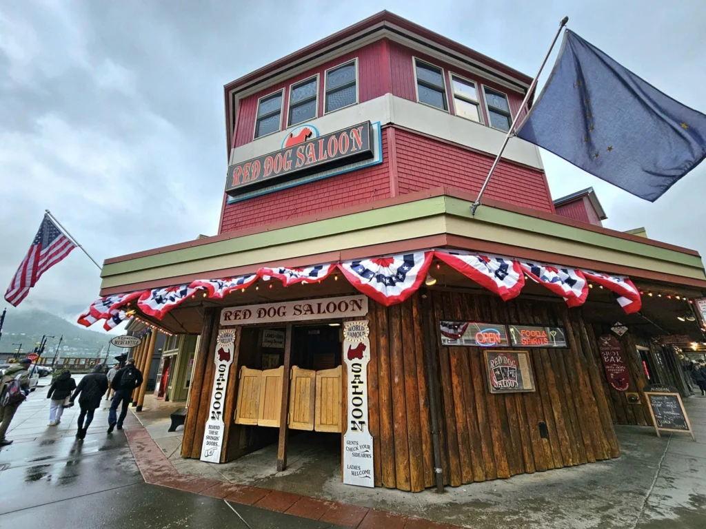 Cruising with Danny and Peter, Holland America Line, Westerdam, Juneau, Alaska, United States | Boat approaching Sentinel Island Lighthouse during Alaska whale watching tour, with humpback whale and stunning coastal scenery in the background.