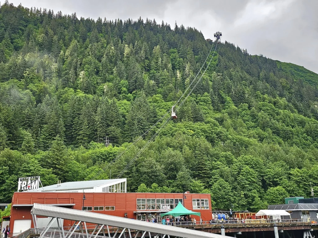 Cruising with Danny and Peter, Holland America Line, Westerdam, Juneau, Alaska, United States | Boat approaching Sentinel Island Lighthouse during Alaska whale watching tour, with humpback whale and stunning coastal scenery in the background.