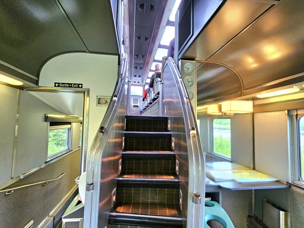 Cruising with Danny and Peter, Holland America Line, Westerdam, Prince Rupert, British Columbia, Canada | In the heart of British Columbia’s wild embrace, Where the Great Bear Rainforest weaves its mystic lace, A journey unfolds, both rail and road in stride, Through nature’s grandeur, where dreams and landscapes collide. From Prince Rupert’s charm, the train departs with grace, A serpentine path through forests’ ancient face, Panoramic windows frame a living, verdant dream, As the Skeena River’s flow whispers its serene theme. Mountains rise like giants, draped in emerald hues, While bald eagles soar, their shadows fleeting views, Black bears wander softly through the forest deep, And mountain goats on rugged cliffs silently leap. Kleanza Creek’s waterfalls cascade with a roar, Nature’s symphony on the rainforest’s floor, And Exchamsiks Park, a jewel of glacial light, Where shimmering pools reflect the day’s pure delight. From rail to road, the scenic drive unveils, A tapestry of mountains and verdant trails, Each turn a canvas painted with the wild’s own hand, A journey through a wonderland, vast and grand. Back in Prince Rupert, where history finds its place, The Museum’s treasures weave a cultural grace, Totem poles and masks tell tales of ancient lore, In this land where the past and present gently soar. Through the Great Bear Rainforest, we wandered wide, In rail and road’s embrace, where nature and culture collide, A journey of wonder, where memories are spun, In the heart of British Columbia, under the sun.