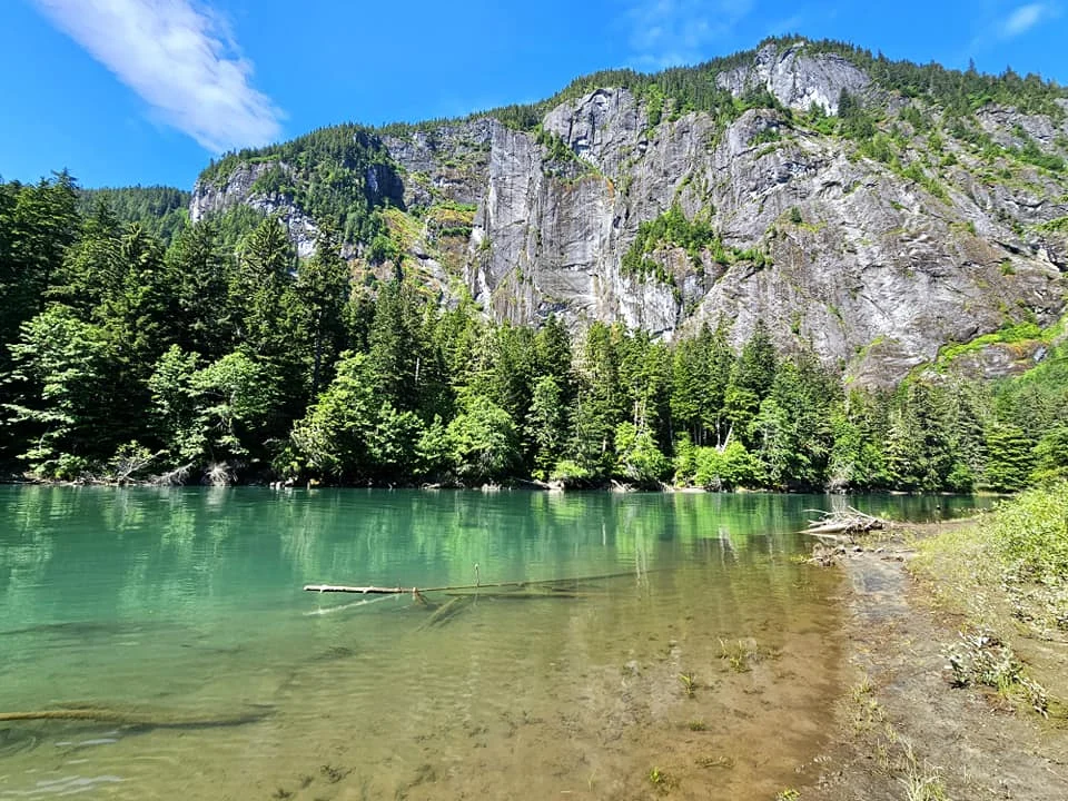 Cruising with Danny and Peter, Holland America Line, Westerdam, Prince Rupert, British Columbia, Canada | In the heart of British Columbia’s wild embrace, Where the Great Bear Rainforest weaves its mystic lace, A journey unfolds, both rail and road in stride, Through nature’s grandeur, where dreams and landscapes collide. From Prince Rupert’s charm, the train departs with grace, A serpentine path through forests’ ancient face, Panoramic windows frame a living, verdant dream, As the Skeena River’s flow whispers its serene theme. Mountains rise like giants, draped in emerald hues, While bald eagles soar, their shadows fleeting views, Black bears wander softly through the forest deep, And mountain goats on rugged cliffs silently leap. Kleanza Creek’s waterfalls cascade with a roar, Nature’s symphony on the rainforest’s floor, And Exchamsiks Park, a jewel of glacial light, Where shimmering pools reflect the day’s pure delight. From rail to road, the scenic drive unveils, A tapestry of mountains and verdant trails, Each turn a canvas painted with the wild’s own hand, A journey through a wonderland, vast and grand. Back in Prince Rupert, where history finds its place, The Museum’s treasures weave a cultural grace, Totem poles and masks tell tales of ancient lore, In this land where the past and present gently soar. Through the Great Bear Rainforest, we wandered wide, In rail and road’s embrace, where nature and culture collide, A journey of wonder, where memories are spun, In the heart of British Columbia, under the sun.