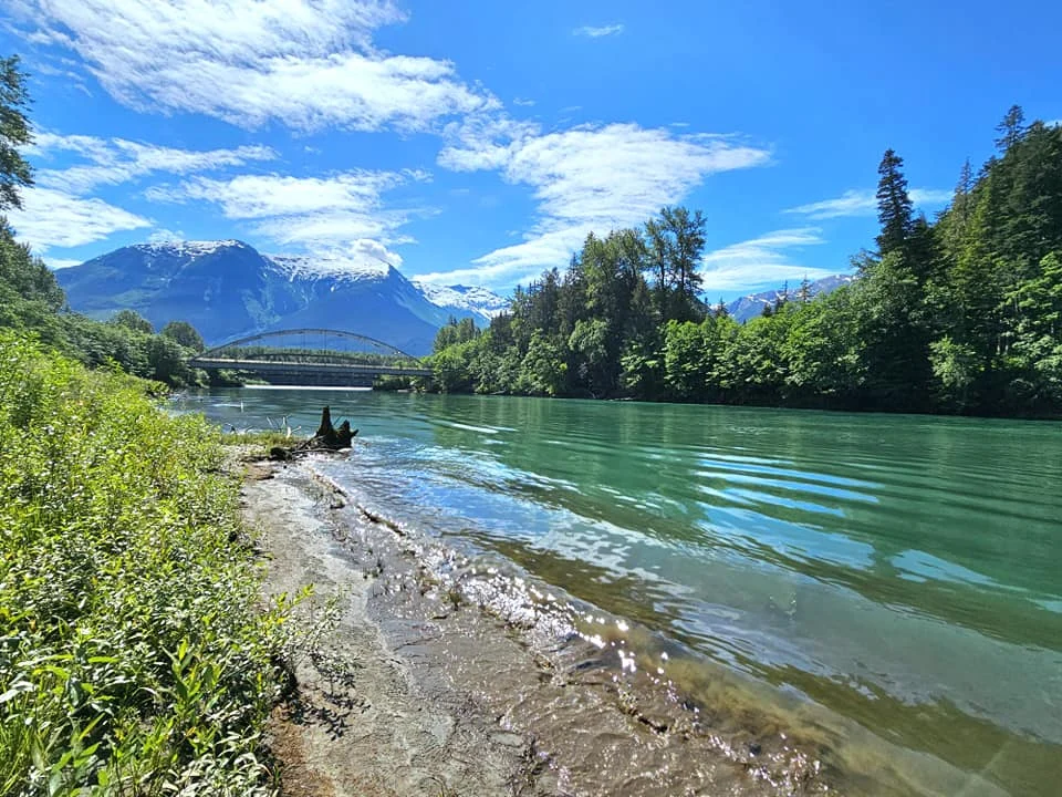 Cruising with Danny and Peter, Holland America Line, Westerdam, Prince Rupert, British Columbia, Canada | In the heart of British Columbia’s wild embrace, Where the Great Bear Rainforest weaves its mystic lace, A journey unfolds, both rail and road in stride, Through nature’s grandeur, where dreams and landscapes collide. From Prince Rupert’s charm, the train departs with grace, A serpentine path through forests’ ancient face, Panoramic windows frame a living, verdant dream, As the Skeena River’s flow whispers its serene theme. Mountains rise like giants, draped in emerald hues, While bald eagles soar, their shadows fleeting views, Black bears wander softly through the forest deep, And mountain goats on rugged cliffs silently leap. Kleanza Creek’s waterfalls cascade with a roar, Nature’s symphony on the rainforest’s floor, And Exchamsiks Park, a jewel of glacial light, Where shimmering pools reflect the day’s pure delight. From rail to road, the scenic drive unveils, A tapestry of mountains and verdant trails, Each turn a canvas painted with the wild’s own hand, A journey through a wonderland, vast and grand. Back in Prince Rupert, where history finds its place, The Museum’s treasures weave a cultural grace, Totem poles and masks tell tales of ancient lore, In this land where the past and present gently soar. Through the Great Bear Rainforest, we wandered wide, In rail and road’s embrace, where nature and culture collide, A journey of wonder, where memories are spun, In the heart of British Columbia, under the sun.