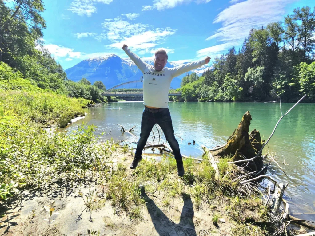 Cruising with Danny and Peter, Holland America Line, Westerdam, Prince Rupert, British Columbia, Canada | In the heart of British Columbia’s wild embrace, Where the Great Bear Rainforest weaves its mystic lace, A journey unfolds, both rail and road in stride, Through nature’s grandeur, where dreams and landscapes collide. From Prince Rupert’s charm, the train departs with grace, A serpentine path through forests’ ancient face, Panoramic windows frame a living, verdant dream, As the Skeena River’s flow whispers its serene theme. Mountains rise like giants, draped in emerald hues, While bald eagles soar, their shadows fleeting views, Black bears wander softly through the forest deep, And mountain goats on rugged cliffs silently leap. Kleanza Creek’s waterfalls cascade with a roar, Nature’s symphony on the rainforest’s floor, And Exchamsiks Park, a jewel of glacial light, Where shimmering pools reflect the day’s pure delight. From rail to road, the scenic drive unveils, A tapestry of mountains and verdant trails, Each turn a canvas painted with the wild’s own hand, A journey through a wonderland, vast and grand. Back in Prince Rupert, where history finds its place, The Museum’s treasures weave a cultural grace, Totem poles and masks tell tales of ancient lore, In this land where the past and present gently soar. Through the Great Bear Rainforest, we wandered wide, In rail and road’s embrace, where nature and culture collide, A journey of wonder, where memories are spun, In the heart of British Columbia, under the sun.