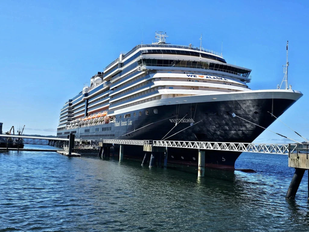 Cruising with Danny and Peter, Holland America Line, Westerdam, Prince Rupert, British Columbia, Canada | In the heart of British Columbia’s wild embrace, Where the Great Bear Rainforest weaves its mystic lace, A journey unfolds, both rail and road in stride, Through nature’s grandeur, where dreams and landscapes collide. From Prince Rupert’s charm, the train departs with grace, A serpentine path through forests’ ancient face, Panoramic windows frame a living, verdant dream, As the Skeena River’s flow whispers its serene theme. Mountains rise like giants, draped in emerald hues, While bald eagles soar, their shadows fleeting views, Black bears wander softly through the forest deep, And mountain goats on rugged cliffs silently leap. Kleanza Creek’s waterfalls cascade with a roar, Nature’s symphony on the rainforest’s floor, And Exchamsiks Park, a jewel of glacial light, Where shimmering pools reflect the day’s pure delight. From rail to road, the scenic drive unveils, A tapestry of mountains and verdant trails, Each turn a canvas painted with the wild’s own hand, A journey through a wonderland, vast and grand. Back in Prince Rupert, where history finds its place, The Museum’s treasures weave a cultural grace, Totem poles and masks tell tales of ancient lore, In this land where the past and present gently soar. Through the Great Bear Rainforest, we wandered wide, In rail and road’s embrace, where nature and culture collide, A journey of wonder, where memories are spun, In the heart of British Columbia, under the sun.