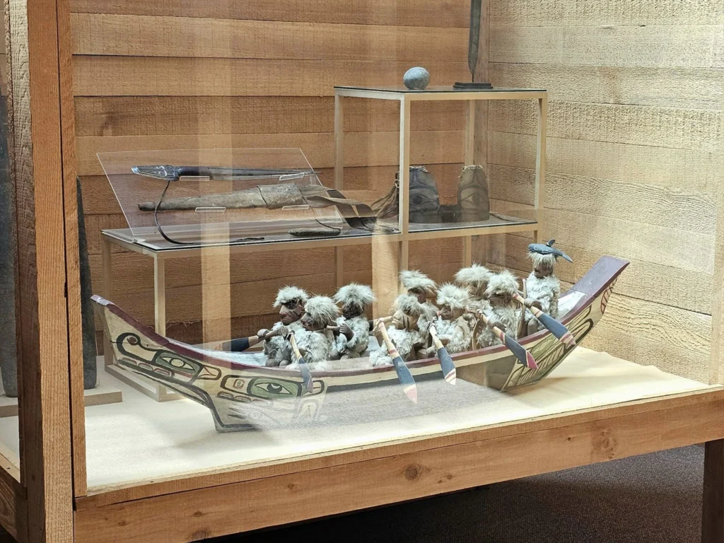 Cruising with Danny and Peter, Holland America Line, Westerdam, Prince Rupert, British Columbia, Canada | In the heart of British Columbia’s wild embrace, Where the Great Bear Rainforest weaves its mystic lace, A journey unfolds, both rail and road in stride, Through nature’s grandeur, where dreams and landscapes collide. From Prince Rupert’s charm, the train departs with grace, A serpentine path through forests’ ancient face, Panoramic windows frame a living, verdant dream, As the Skeena River’s flow whispers its serene theme. Mountains rise like giants, draped in emerald hues, While bald eagles soar, their shadows fleeting views, Black bears wander softly through the forest deep, And mountain goats on rugged cliffs silently leap. Kleanza Creek’s waterfalls cascade with a roar, Nature’s symphony on the rainforest’s floor, And Exchamsiks Park, a jewel of glacial light, Where shimmering pools reflect the day’s pure delight. From rail to road, the scenic drive unveils, A tapestry of mountains and verdant trails, Each turn a canvas painted with the wild’s own hand, A journey through a wonderland, vast and grand. Back in Prince Rupert, where history finds its place, The Museum’s treasures weave a cultural grace, Totem poles and masks tell tales of ancient lore, In this land where the past and present gently soar. Through the Great Bear Rainforest, we wandered wide, In rail and road’s embrace, where nature and culture collide, A journey of wonder, where memories are spun, In the heart of British Columbia, under the sun.