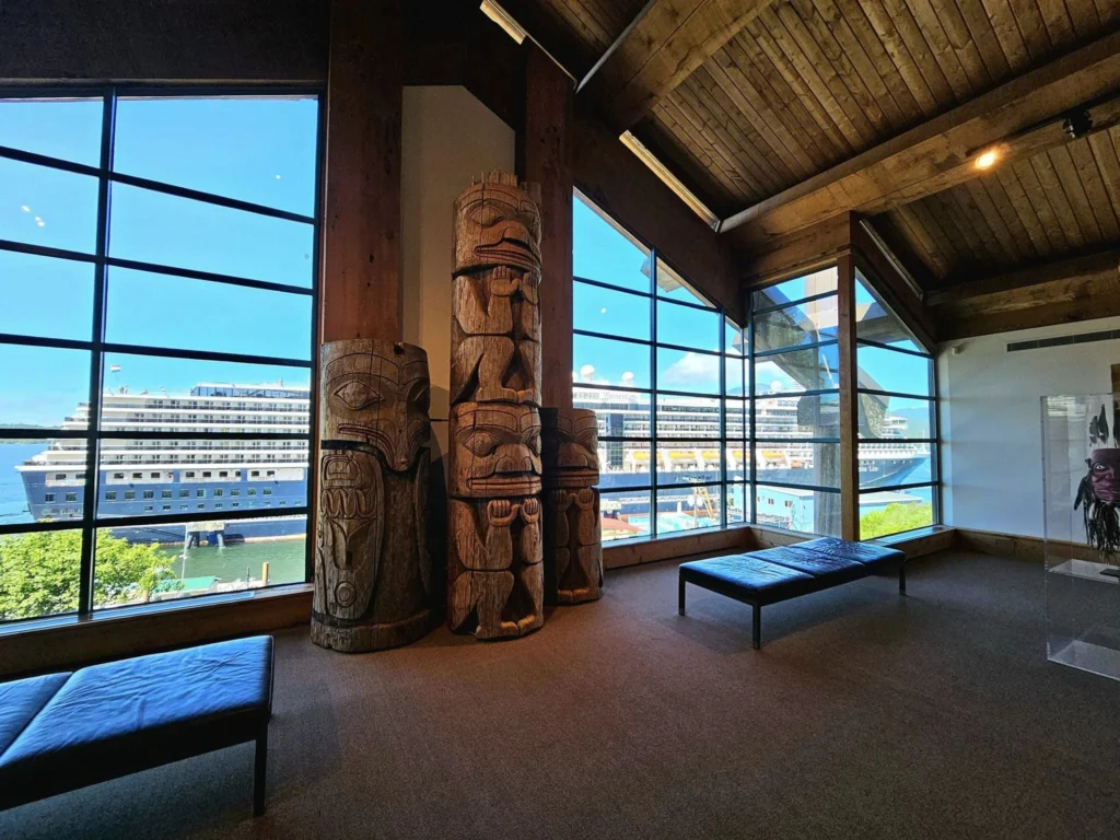 Cruising with Danny and Peter, Holland America Line, Westerdam, Prince Rupert, British Columbia, Canada | In the heart of British Columbia’s wild embrace, Where the Great Bear Rainforest weaves its mystic lace, A journey unfolds, both rail and road in stride, Through nature’s grandeur, where dreams and landscapes collide. From Prince Rupert’s charm, the train departs with grace, A serpentine path through forests’ ancient face, Panoramic windows frame a living, verdant dream, As the Skeena River’s flow whispers its serene theme. Mountains rise like giants, draped in emerald hues, While bald eagles soar, their shadows fleeting views, Black bears wander softly through the forest deep, And mountain goats on rugged cliffs silently leap. Kleanza Creek’s waterfalls cascade with a roar, Nature’s symphony on the rainforest’s floor, And Exchamsiks Park, a jewel of glacial light, Where shimmering pools reflect the day’s pure delight. From rail to road, the scenic drive unveils, A tapestry of mountains and verdant trails, Each turn a canvas painted with the wild’s own hand, A journey through a wonderland, vast and grand. Back in Prince Rupert, where history finds its place, The Museum’s treasures weave a cultural grace, Totem poles and masks tell tales of ancient lore, In this land where the past and present gently soar. Through the Great Bear Rainforest, we wandered wide, In rail and road’s embrace, where nature and culture collide, A journey of wonder, where memories are spun, In the heart of British Columbia, under the sun.