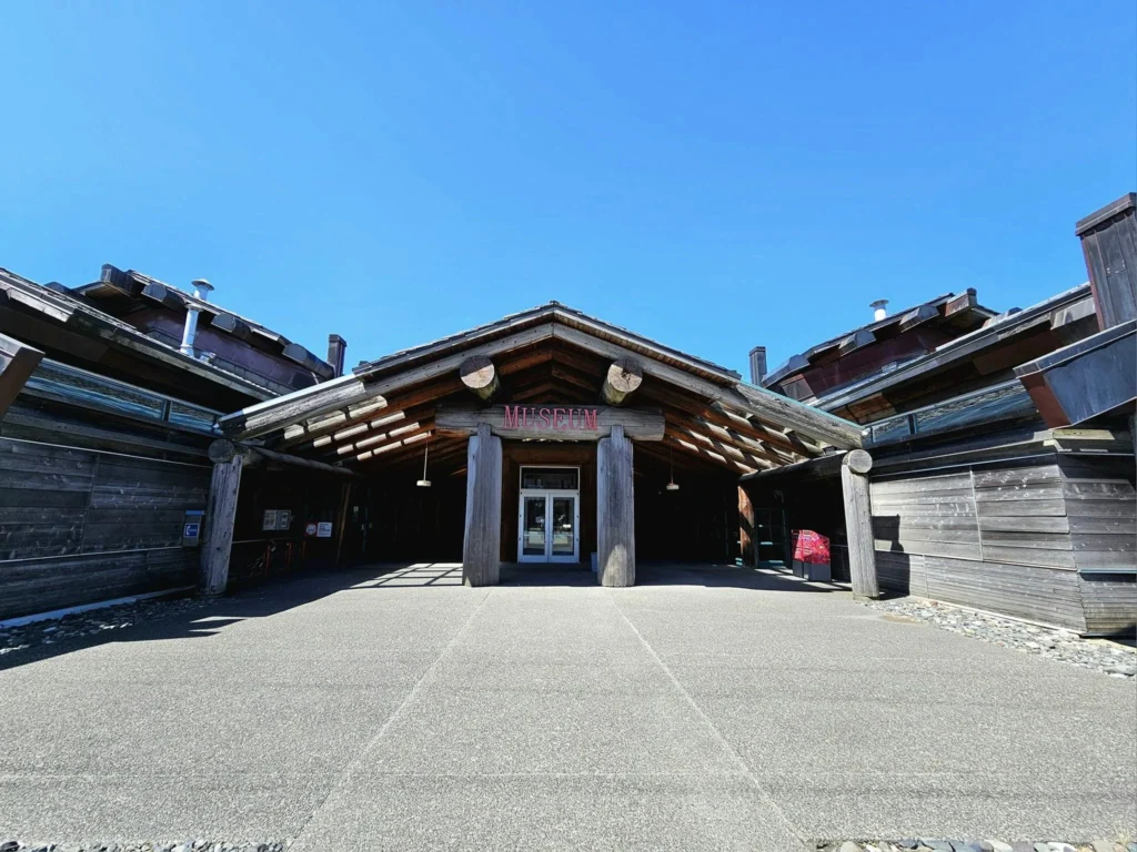 Cruising with Danny and Peter, Holland America Line, Westerdam, Prince Rupert, British Columbia, Canada | In the heart of British Columbia’s wild embrace, Where the Great Bear Rainforest weaves its mystic lace, A journey unfolds, both rail and road in stride, Through nature’s grandeur, where dreams and landscapes collide. From Prince Rupert’s charm, the train departs with grace, A serpentine path through forests’ ancient face, Panoramic windows frame a living, verdant dream, As the Skeena River’s flow whispers its serene theme. Mountains rise like giants, draped in emerald hues, While bald eagles soar, their shadows fleeting views, Black bears wander softly through the forest deep, And mountain goats on rugged cliffs silently leap. Kleanza Creek’s waterfalls cascade with a roar, Nature’s symphony on the rainforest’s floor, And Exchamsiks Park, a jewel of glacial light, Where shimmering pools reflect the day’s pure delight. From rail to road, the scenic drive unveils, A tapestry of mountains and verdant trails, Each turn a canvas painted with the wild’s own hand, A journey through a wonderland, vast and grand. Back in Prince Rupert, where history finds its place, The Museum’s treasures weave a cultural grace, Totem poles and masks tell tales of ancient lore, In this land where the past and present gently soar. Through the Great Bear Rainforest, we wandered wide, In rail and road’s embrace, where nature and culture collide, A journey of wonder, where memories are spun, In the heart of British Columbia, under the sun.