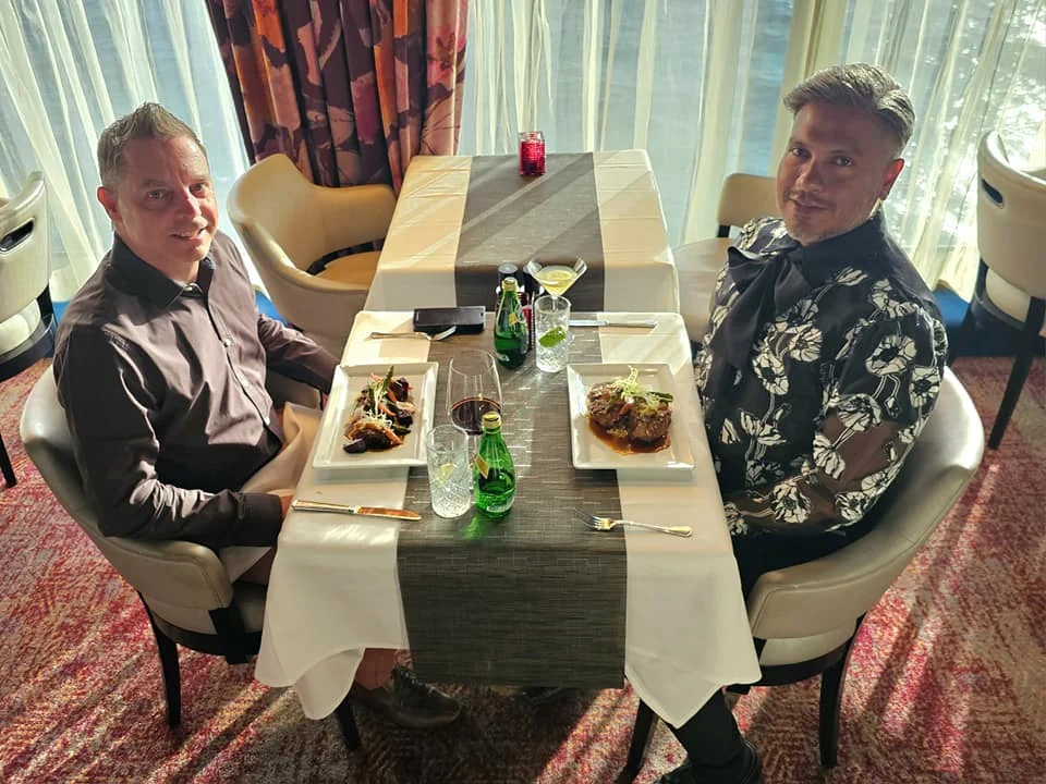 Cruising with Danny and Peter, Holland America Line, Westerdam, Seattle, Washington, United States | Stunning sunset over the ocean during a magical evening cruise from Prince Rupert on the Westerdam, with vibrant orange and pink skies reflecting on calm waters.