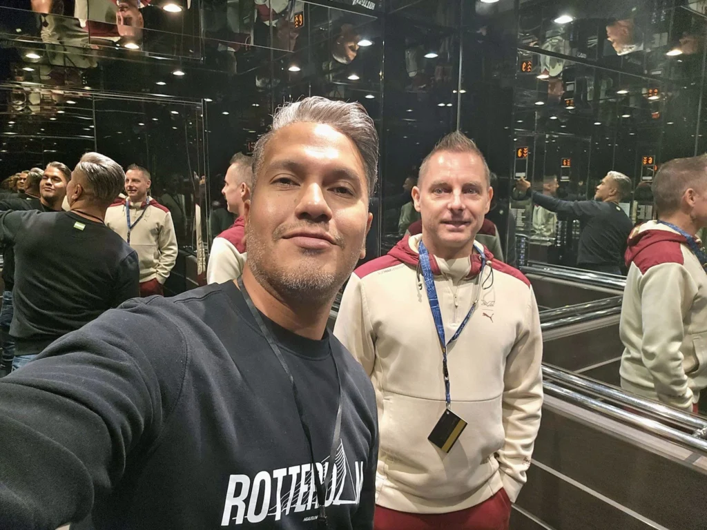 Cruising with Danny and Peter, MSC Cruises, MSC Preziosa, Rotterdam, The Netherlands, Birthday Cruise | The majestic MSC Preziosa cruise ship docked at Rotterdam’s Cruise Terminal on Wilhelminakade, its sleek white exterior gleaming against the modern city skyline with the iconic Erasmus Bridge in the background. Passengers board for a Northern Europe mini-cruise, celebrating a birthday with luxurious touches like a chilled bottle of Spumante and macarons in a stylish cabin. The vibrant onboard atmosphere features a gourmet dining experience at Butcher’s Cut Chef’s Table with a surprise birthday cake, thrilling entertainment at the Platinum Theater’s Rock Nation show with singers and dancers, and a lively Silent Disco in the Safari Lounge. The scene captures the excitement of embarkation day, with scenic views of Rotterdam’s waterfront, onboard shopping for MSC souvenirs, and the promise of an unforgettable luxury cruise vacation.