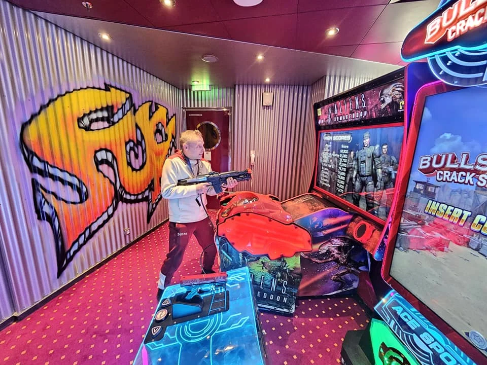 Cruising with Danny and Peter, MSC Cruises, MSC Preziosa, Rotterdam, The Netherlands, Birthday Cruise | The majestic MSC Preziosa cruise ship docked at Rotterdam’s Cruise Terminal on Wilhelminakade, its sleek white exterior gleaming against the modern city skyline with the iconic Erasmus Bridge in the background. Passengers board for a Northern Europe mini-cruise, celebrating a birthday with luxurious touches like a chilled bottle of Spumante and macarons in a stylish cabin. The vibrant onboard atmosphere features a gourmet dining experience at Butcher’s Cut Chef’s Table with a surprise birthday cake, thrilling entertainment at the Platinum Theater’s Rock Nation show with singers and dancers, and a lively Silent Disco in the Safari Lounge. The scene captures the excitement of embarkation day, with scenic views of Rotterdam’s waterfront, onboard shopping for MSC souvenirs, and the promise of an unforgettable luxury cruise vacation.