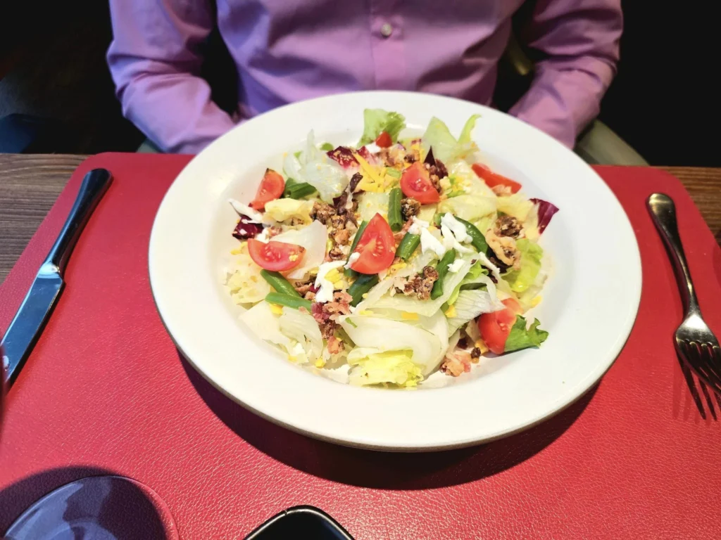 Cruising with Danny and Peter, MSC Cruises, MSC Preziosa, Rotterdam, The Netherlands, Birthday Cruise | The majestic MSC Preziosa cruise ship docked at Rotterdam’s Cruise Terminal on Wilhelminakade, its sleek white exterior gleaming against the modern city skyline with the iconic Erasmus Bridge in the background. Passengers board for a Northern Europe mini-cruise, celebrating a birthday with luxurious touches like a chilled bottle of Spumante and macarons in a stylish cabin. The vibrant onboard atmosphere features a gourmet dining experience at Butcher’s Cut Chef’s Table with a surprise birthday cake, thrilling entertainment at the Platinum Theater’s Rock Nation show with singers and dancers, and a lively Silent Disco in the Safari Lounge. The scene captures the excitement of embarkation day, with scenic views of Rotterdam’s waterfront, onboard shopping for MSC souvenirs, and the promise of an unforgettable luxury cruise vacation.