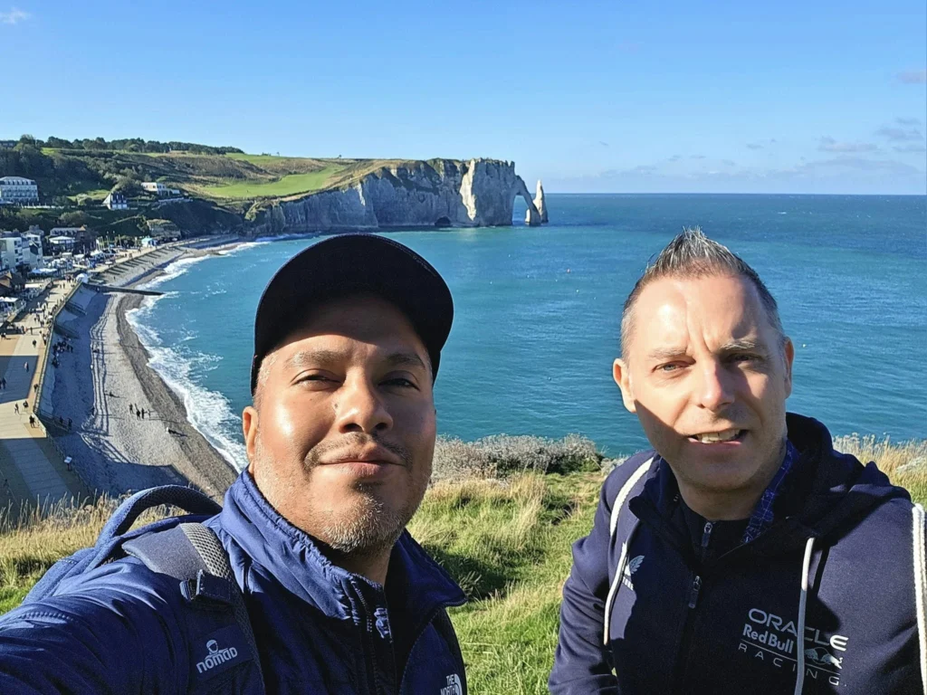 Cruising with Danny and Peter, MSC Cruises, MSC Preziosa, Le Havre, Paris, Étretat, France | Stunning views of the Étretat natural arches against the Normandy coastline, featuring the iconic L'Aiguille rock formation, picturesque half-timbered houses in Étretat, and travelers enjoying scenic walks along the cliffs during the unguided tour from MSC Preziosa.