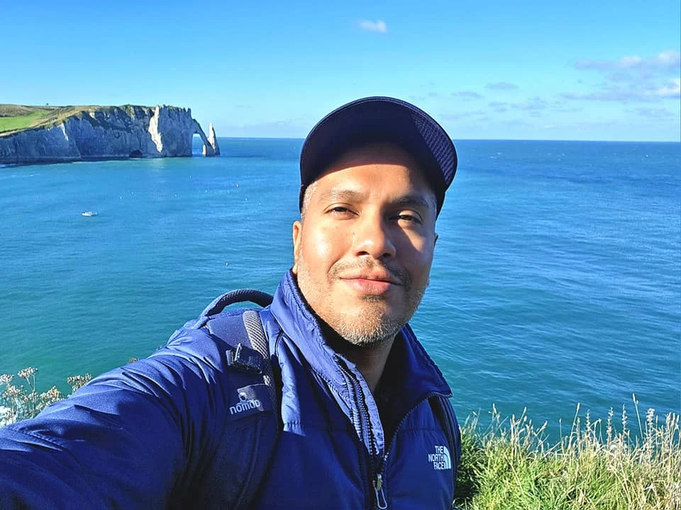 Cruising with Danny and Peter, MSC Cruises, MSC Preziosa, Le Havre, Paris, Étretat, France | Stunning views of the Étretat natural arches against the Normandy coastline, featuring the iconic L'Aiguille rock formation, picturesque half-timbered houses in Étretat, and travelers enjoying scenic walks along the cliffs during the unguided tour from MSC Preziosa.