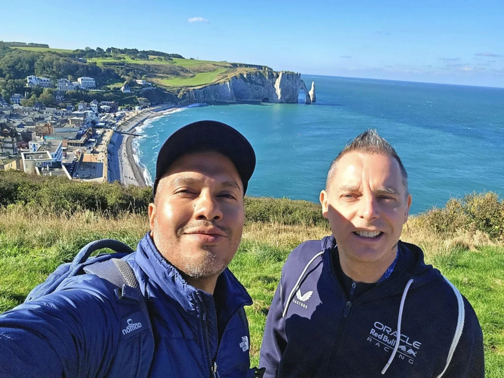 Cruising with Danny and Peter, MSC Cruises, MSC Preziosa, Le Havre, Paris, Étretat, France | Stunning views of the Étretat natural arches against the Normandy coastline, featuring the iconic L'Aiguille rock formation, picturesque half-timbered houses in Étretat, and travelers enjoying scenic walks along the cliffs during the unguided tour from MSC Preziosa.