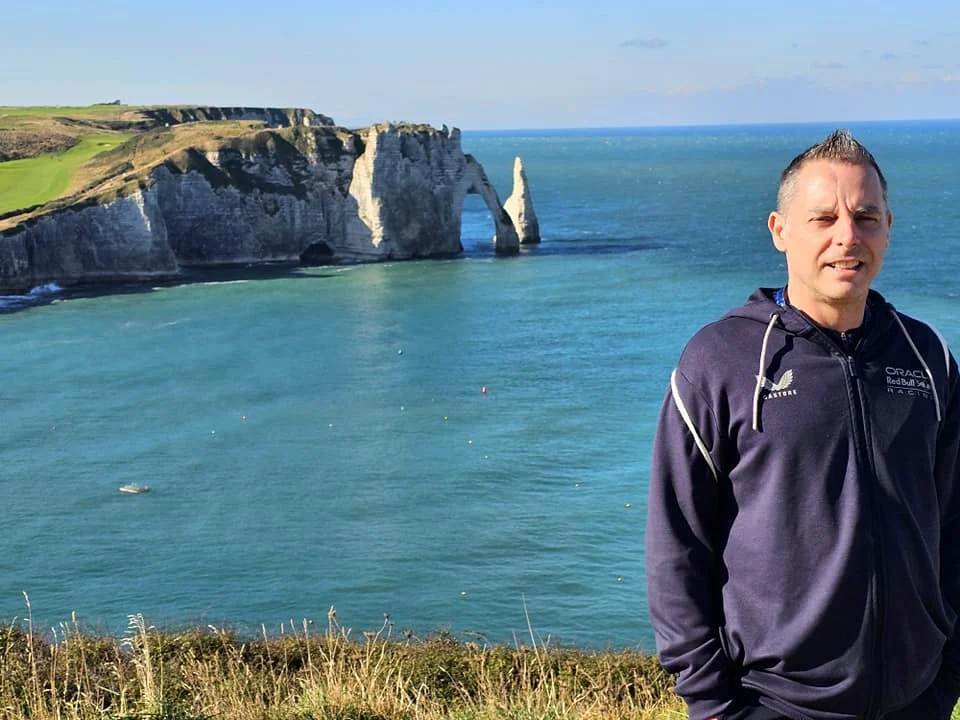 Cruising with Danny and Peter, MSC Cruises, MSC Preziosa, Le Havre, Paris, Étretat, France | Stunning views of the Étretat natural arches against the Normandy coastline, featuring the iconic L'Aiguille rock formation, picturesque half-timbered houses in Étretat, and travelers enjoying scenic walks along the cliffs during the unguided tour from MSC Preziosa.