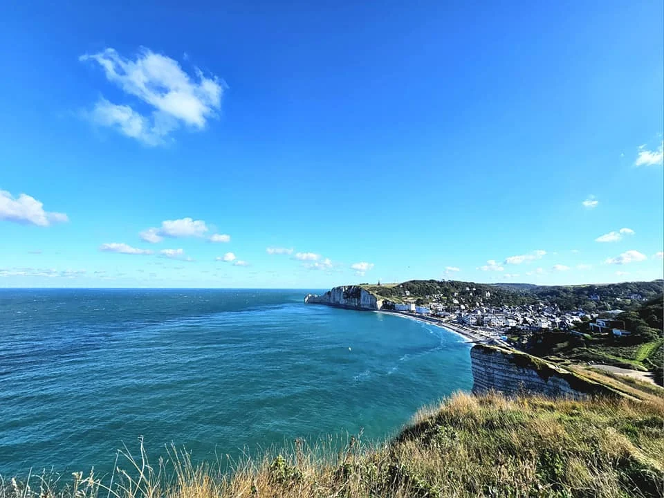 Cruising with Danny and Peter, MSC Cruises, MSC Preziosa, Le Havre, Paris, Étretat, France | Stunning views of the Étretat natural arches against the Normandy coastline, featuring the iconic L'Aiguille rock formation, picturesque half-timbered houses in Étretat, and travelers enjoying scenic walks along the cliffs during the unguided tour from MSC Preziosa.