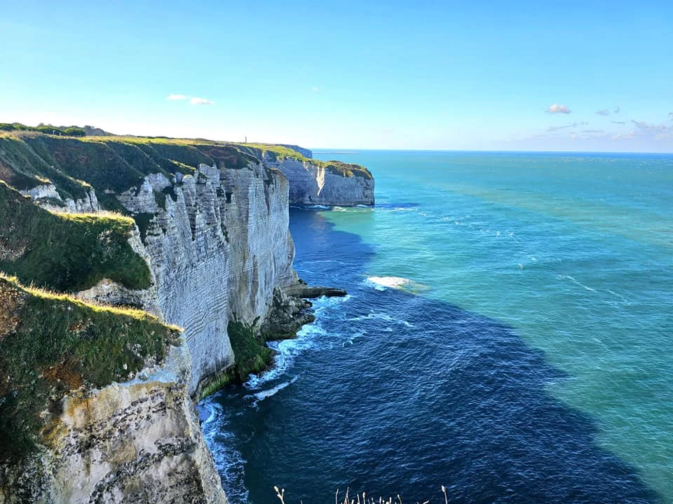 Cruising with Danny and Peter, MSC Cruises, MSC Preziosa, Le Havre, Paris, Étretat, France | Stunning views of the Étretat natural arches against the Normandy coastline, featuring the iconic L'Aiguille rock formation, picturesque half-timbered houses in Étretat, and travelers enjoying scenic walks along the cliffs during the unguided tour from MSC Preziosa.