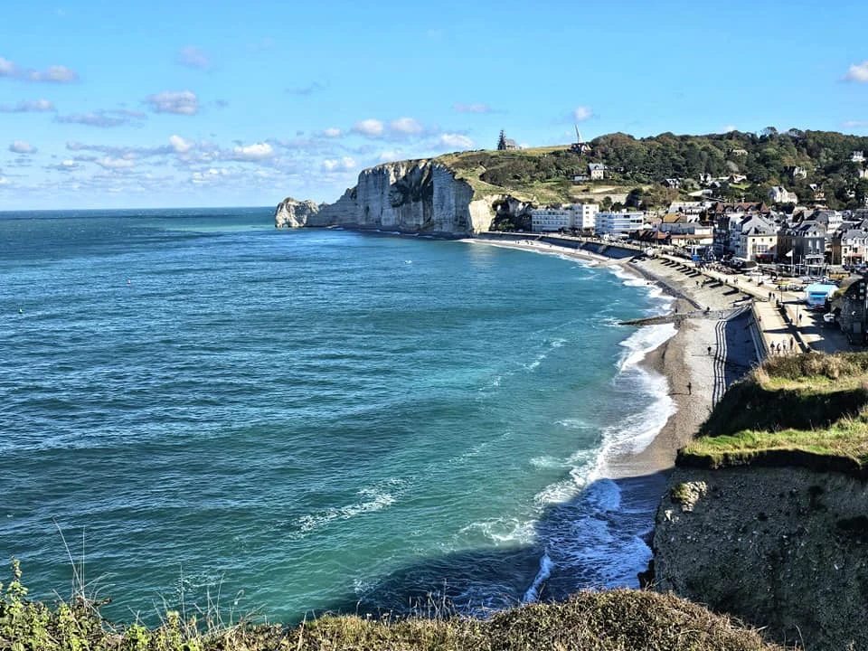 Cruising with Danny and Peter, MSC Cruises, MSC Preziosa, Le Havre, Paris, Étretat, France | Stunning views of the Étretat natural arches against the Normandy coastline, featuring the iconic L'Aiguille rock formation, picturesque half-timbered houses in Étretat, and travelers enjoying scenic walks along the cliffs during the unguided tour from MSC Preziosa.