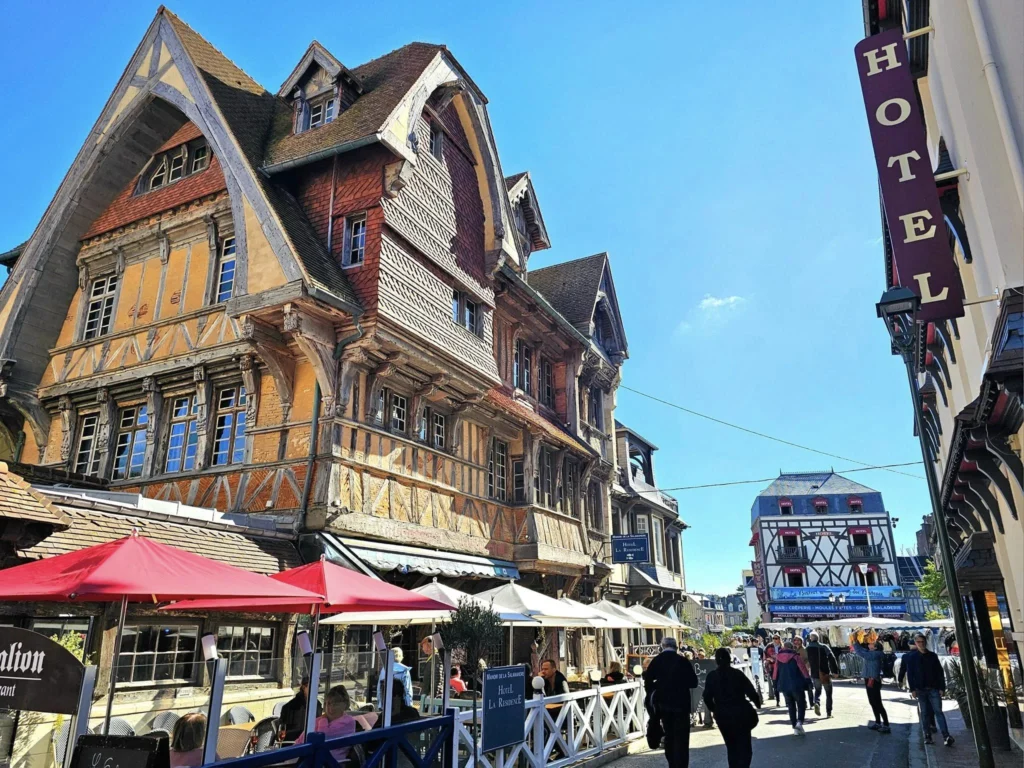 Cruising with Danny and Peter, MSC Cruises, MSC Preziosa, Le Havre, Paris, Étretat, France | Stunning views of the Étretat natural arches against the Normandy coastline, featuring the iconic L'Aiguille rock formation, picturesque half-timbered houses in Étretat, and travelers enjoying scenic walks along the cliffs during the unguided tour from MSC Preziosa.