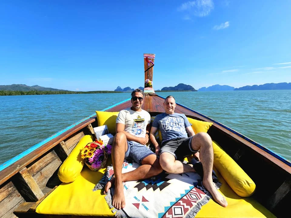 Cruising with Danny and Peter, Holland America Line, Westerdam, Phuket, Thailand | Longtail boat navigating clear waters near James Bond Island, showcasing iconic limestone cliffs. Enjoy dining at a floating restaurant on Phang Nga Bay, kayaking through lush mangroves, and exploring hidden caves with unique rock formations during an unforgettable Phuket island tour.