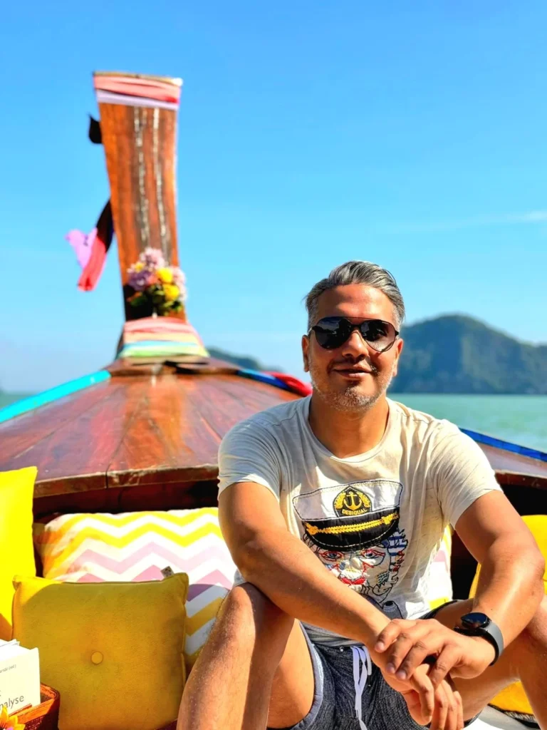 Cruising with Danny and Peter, Holland America Line, Westerdam, Phuket, Thailand | Longtail boat navigating clear waters near James Bond Island, showcasing iconic limestone cliffs. Enjoy dining at a floating restaurant on Phang Nga Bay, kayaking through lush mangroves, and exploring hidden caves with unique rock formations during an unforgettable Phuket island tour.