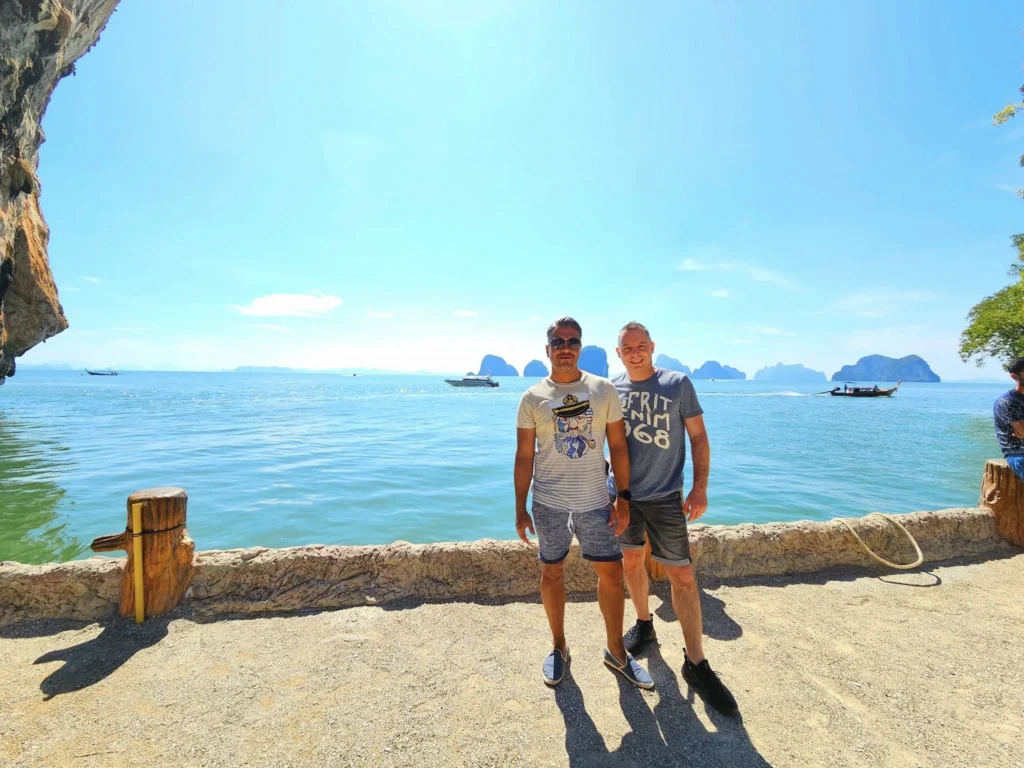 Cruising with Danny and Peter, Holland America Line, Westerdam, Phuket, Thailand | Longtail boat navigating clear waters near James Bond Island, showcasing iconic limestone cliffs. Enjoy dining at a floating restaurant on Phang Nga Bay, kayaking through lush mangroves, and exploring hidden caves with unique rock formations during an unforgettable Phuket island tour.