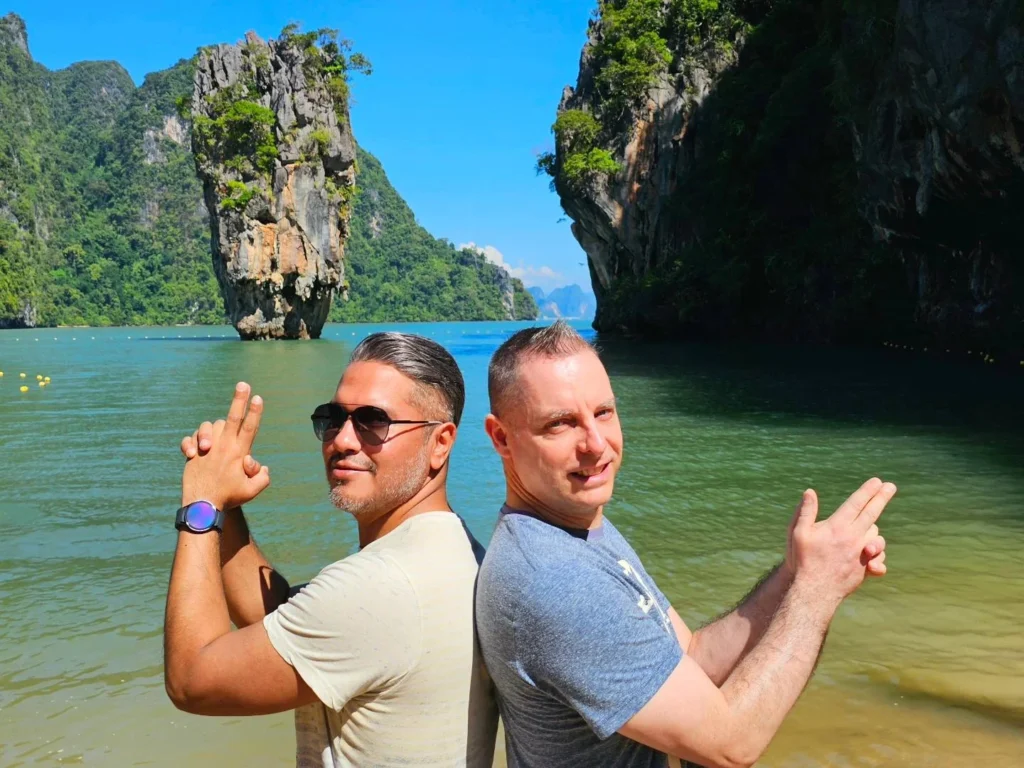 Cruising with Danny and Peter, Holland America Line, Westerdam, Phuket, Thailand | Longtail boat navigating clear waters near James Bond Island, showcasing iconic limestone cliffs. Enjoy dining at a floating restaurant on Phang Nga Bay, kayaking through lush mangroves, and exploring hidden caves with unique rock formations during an unforgettable Phuket island tour.