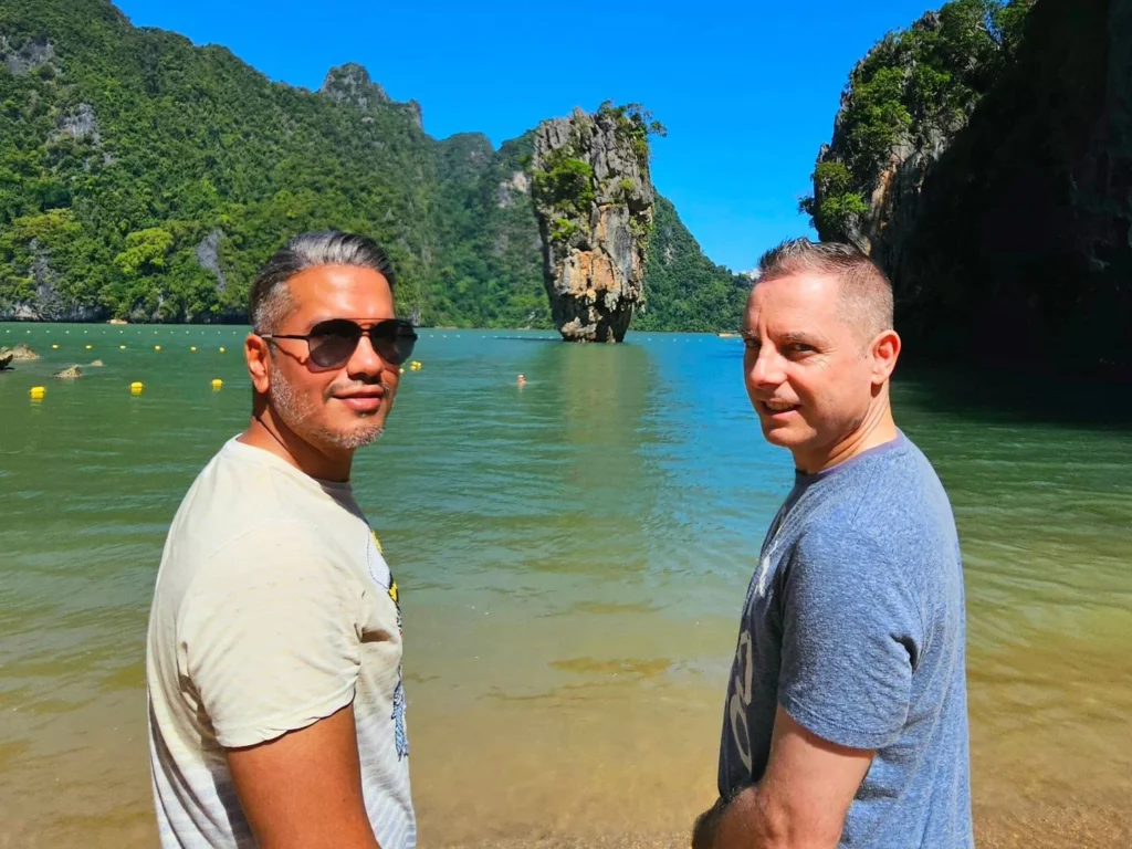 Cruising with Danny and Peter, Holland America Line, Westerdam, Phuket, Thailand | Longtail boat navigating clear waters near James Bond Island, showcasing iconic limestone cliffs. Enjoy dining at a floating restaurant on Phang Nga Bay, kayaking through lush mangroves, and exploring hidden caves with unique rock formations during an unforgettable Phuket island tour.