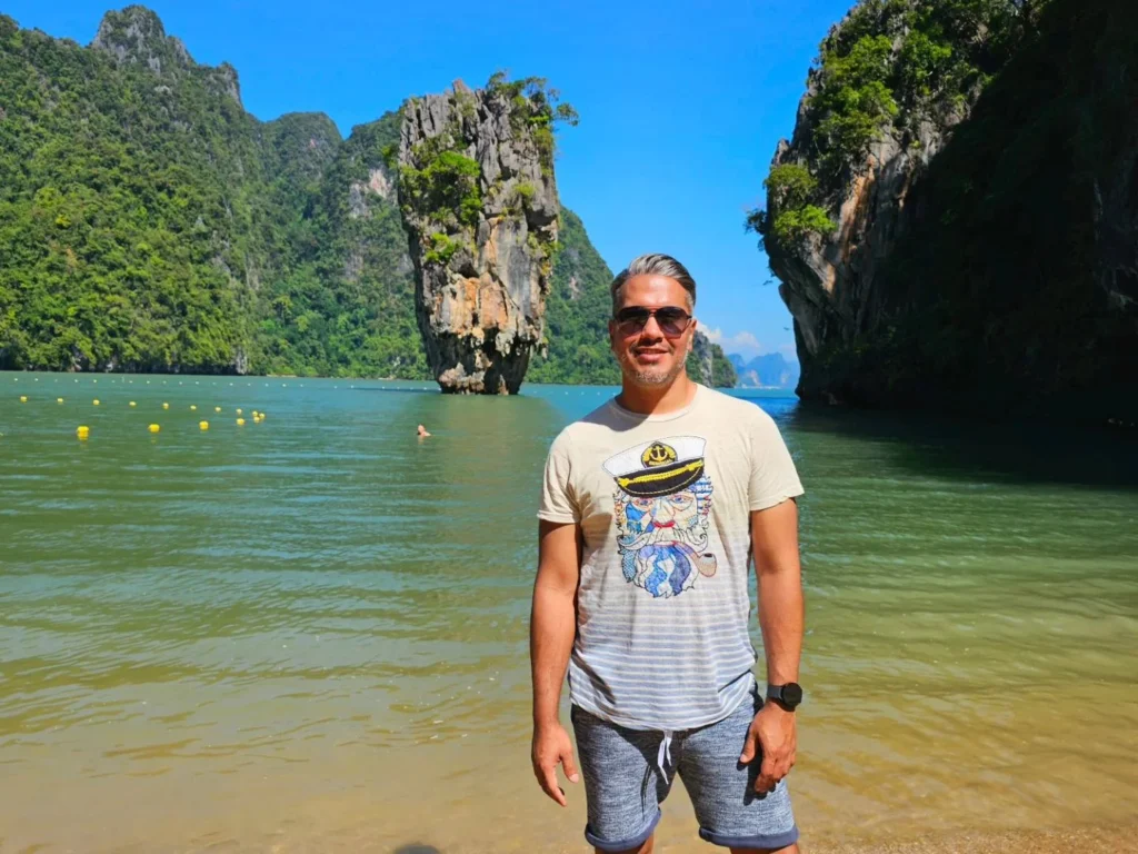 Cruising with Danny and Peter, Holland America Line, Westerdam, Phuket, Thailand | Longtail boat navigating clear waters near James Bond Island, showcasing iconic limestone cliffs. Enjoy dining at a floating restaurant on Phang Nga Bay, kayaking through lush mangroves, and exploring hidden caves with unique rock formations during an unforgettable Phuket island tour.